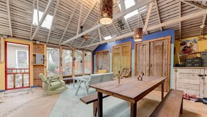Un interior rústico con una mesa de madera, bancos y un techo con vigas a la vista.