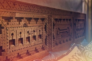 A detailed wooden carving with geometric patterns and animal figures.