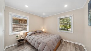 A bedroom with a bed, two windows, a nightstand, and a lamp. - Single Family home in Schaumburg, IL 3 bed/ 2 full baths/ fully fenced backyard (Schaumburg)