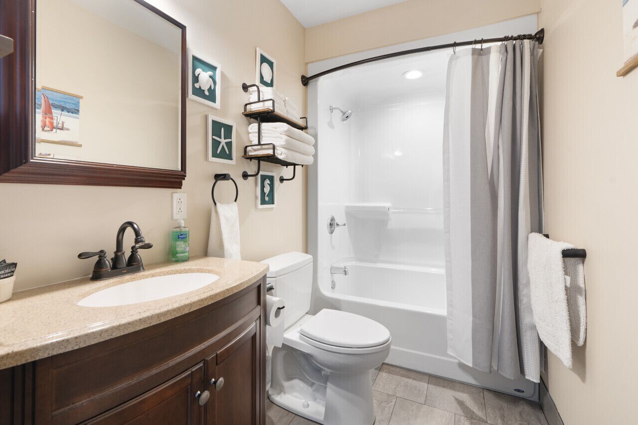 A bathroom with a sink, toilet, and bathtub.