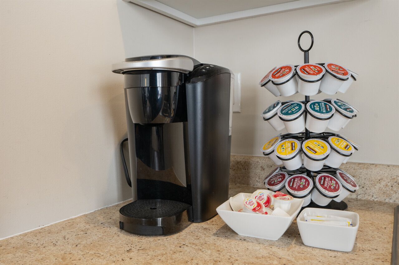 Una cafetera y un portavasos con varias tazas de café.