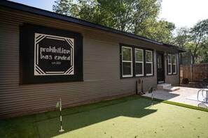 Un edificio con un letrero que dice "prohibition has ended" y un pequeño patio con un asta de banderas.