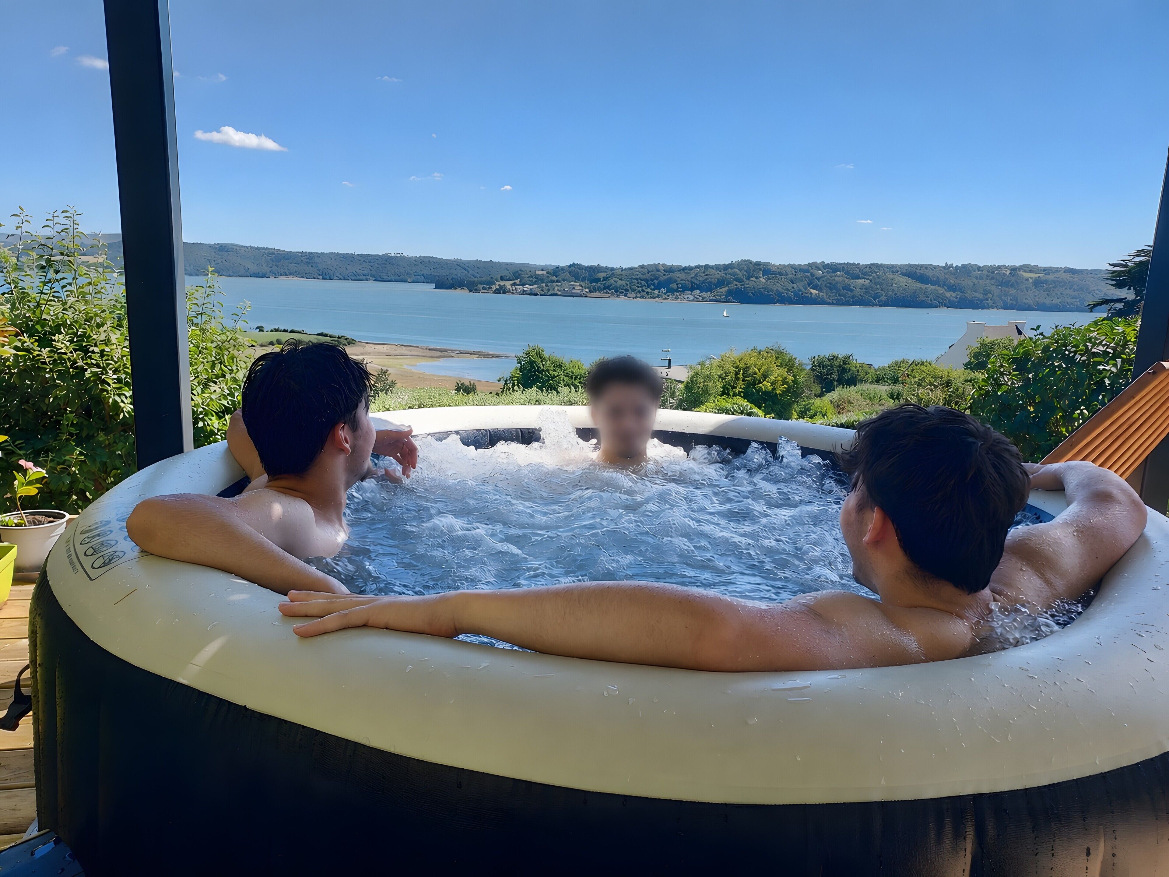 Ein Whirlpool mit Blick auf einen See und Hügel.