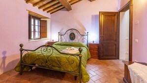 A bedroom with a bed, a window, a door, and a wooden ceiling. - Villa "Podere Spagliarda" with Private Pool, Terrace & Wi-Fi (San Quirico d'Orcia)