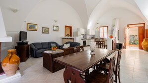 A spacious living area with a dining table, sofas, and a kitchen in the background. - Vacation Home "Villa Stella" with Private Terraces & Private Garden (alezio)