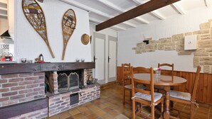 Een rustiek interieur met een bakstenen openhaard, een houten eettafel en stoelen.