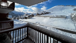 Paisaje nevado con vista a un complejo de edificios tipo chalé y una pista de esquí.