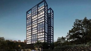 Een modern hoog gebouw met meerdere verdiepingen, grote ramen en een opvallende hoekstructuur.