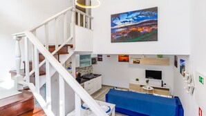 Ein modernes Interieur mit Treppe, Essbereich, Küche und Wohnbereich.