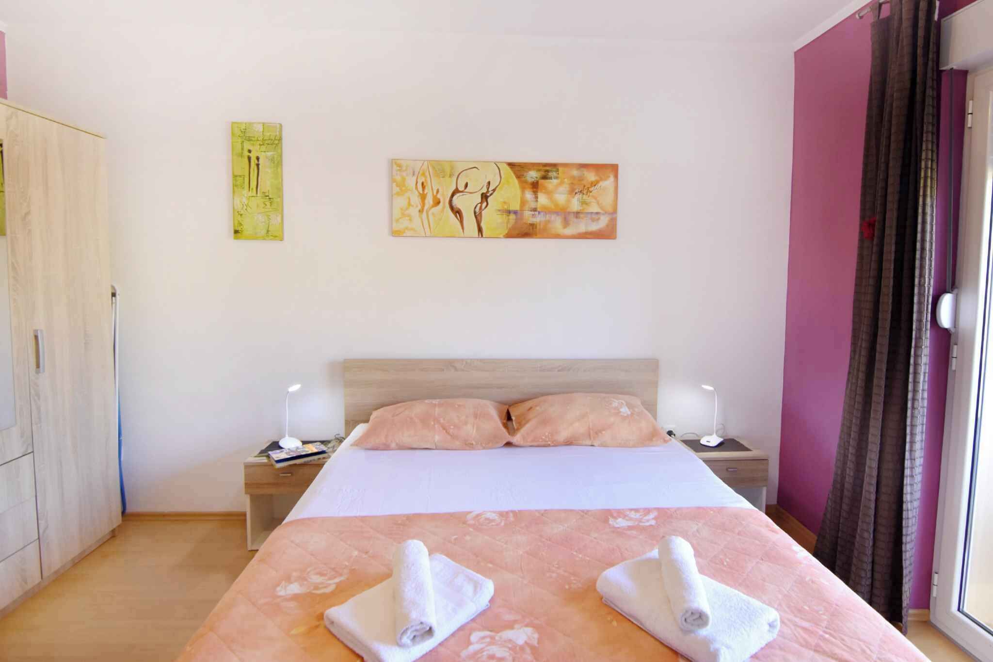 A hotel room with a bed, two bedside tables, a wardrobe, and artwork on the walls.