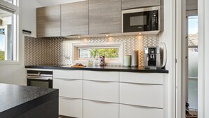 A modern kitchen with a built-in microwave, a coffee machine, and a window with a view of greenery. - Nice home in Kerteminde with WiFi (Kerteminde)