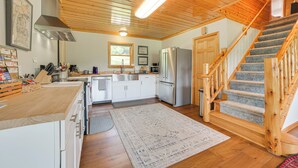 Una cucina con mobili in legno, un frigorifero in acciaio inossidabile e una scala in legno.