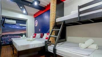 A hotel room with two beds, a window with a cityscape view, a mural of the moon, and a ladder.