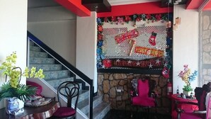 A staircase with a red handrail, a stone wall, and a festive decoration with a Christmas theme. - Sabel Travelers Inn (Laoag)