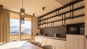 Eine moderne Küche mit Holzausstattung, einer Bosch-Mikrowelle und Bergblick durch große Fenster.