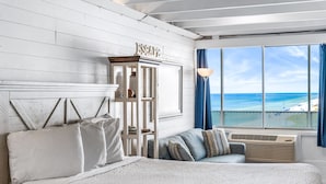 A bedroom with a large bed, a nightstand, a dresser, and a view of the ocean. - FREE Beach Service!  Endless View 702 - New Listing (Panama City Beach)