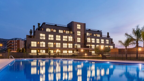 A modern hotel with a swimming pool, multiple balconies, and a view of the surrounding landscape. - Apartamento Moderno y Confortable con Piscina Comunitaria (Verger)