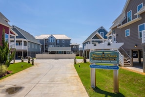 A residential complex with a central building and multiple houses. A sign indicates it is a private beachside resort.