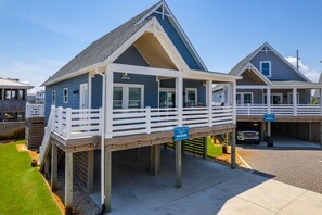A coastal building with a balcony, a covered area, and a garage.