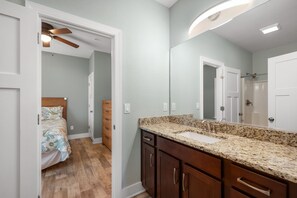 A bathroom with a granite countertop, a sink, and a mirror.