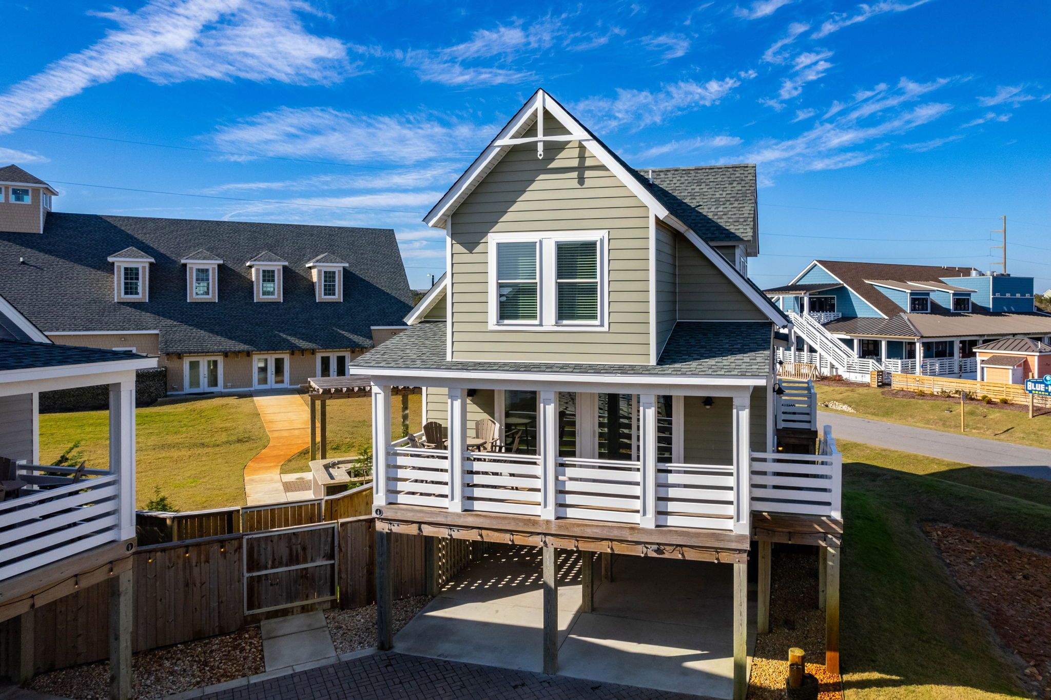 A residential property with a covered deck, a fenced backyard, and a neighboring house.