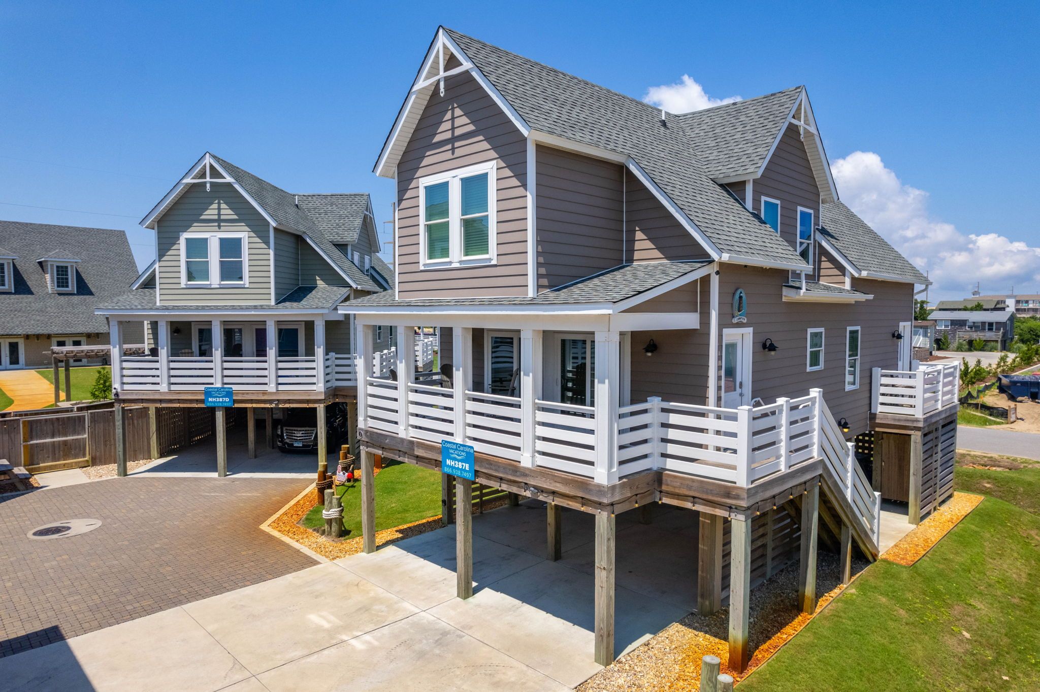A two-story house with a balcony and a deck, featuring a garage and a driveway.