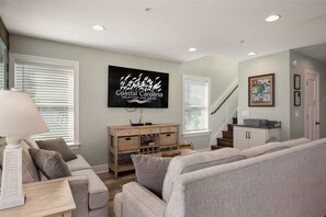 A living room with a television, a sofa, a lamp, and a wooden cabinet.
