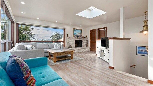 A spacious living area with a sofa, coffee table, and fireplace.
