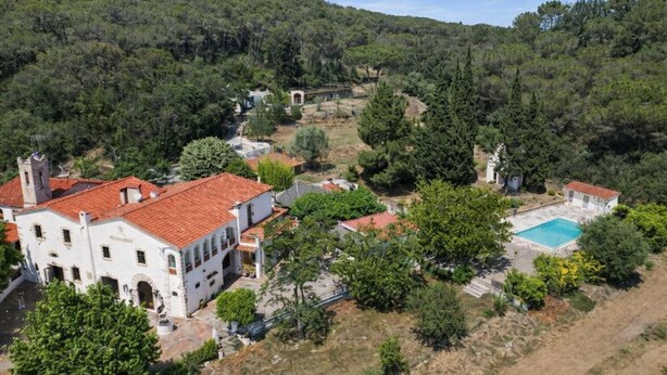 A villa with a red-tiled roof, surrounded by lush greenery and a swimming pool. - Unique 16th-Century Masia: Pool & Private Events (Barcelona)