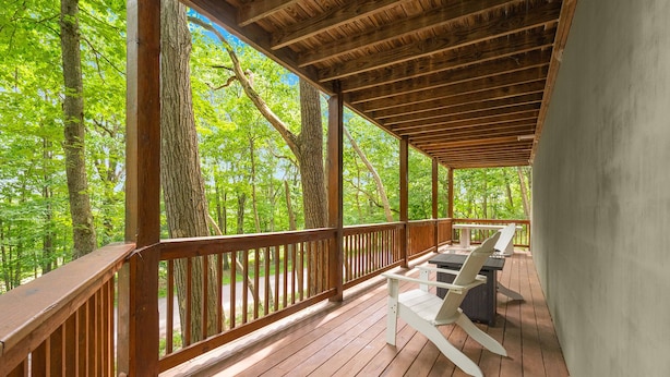 A wooden deck with a railing, white chairs, and a table. - Private Lake/Beach Cabin w/Golf, Pool, Fire pit (Terra Alta)