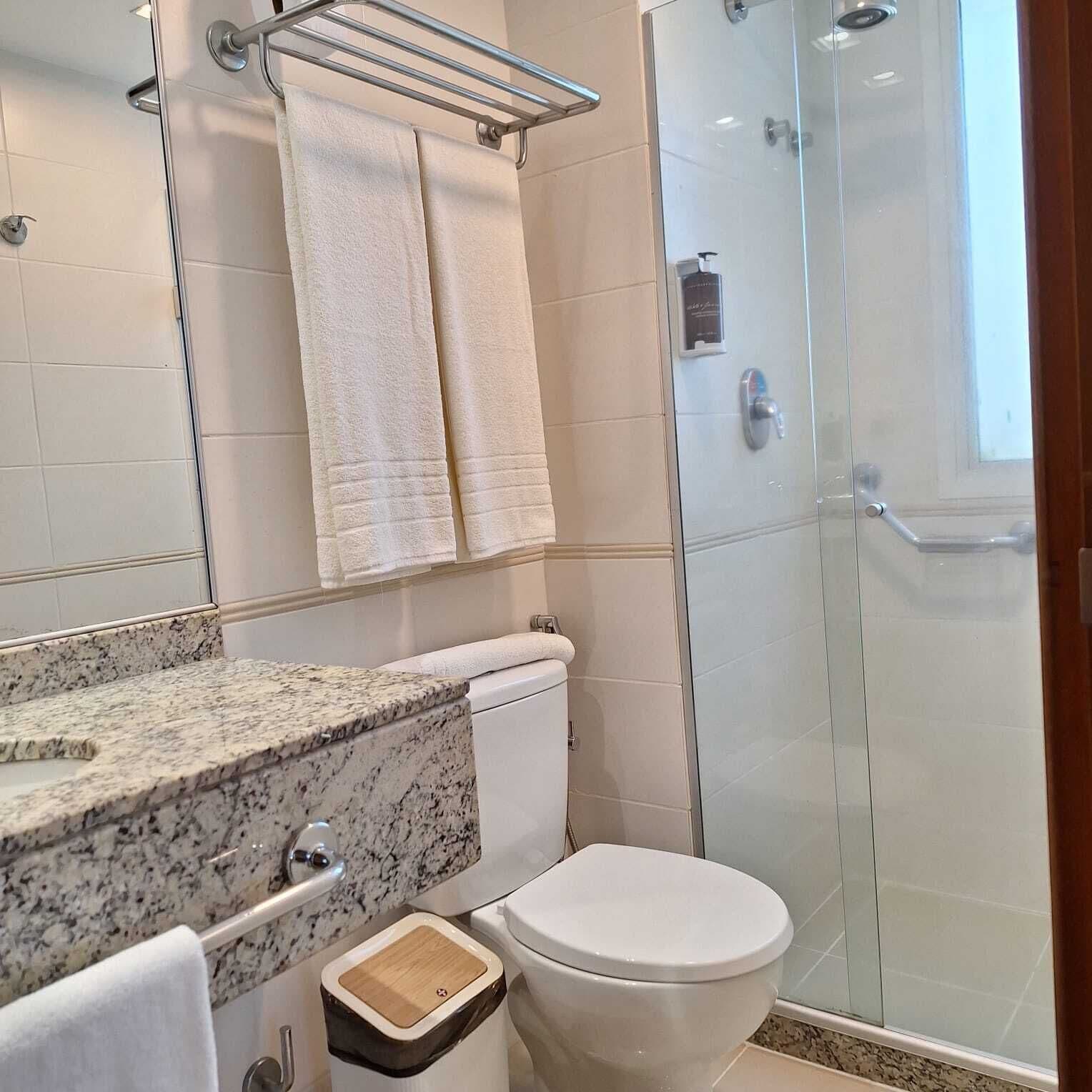 A bathroom with a toilet, sink, and shower.