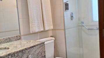 A bathroom with a toilet, sink, and shower.