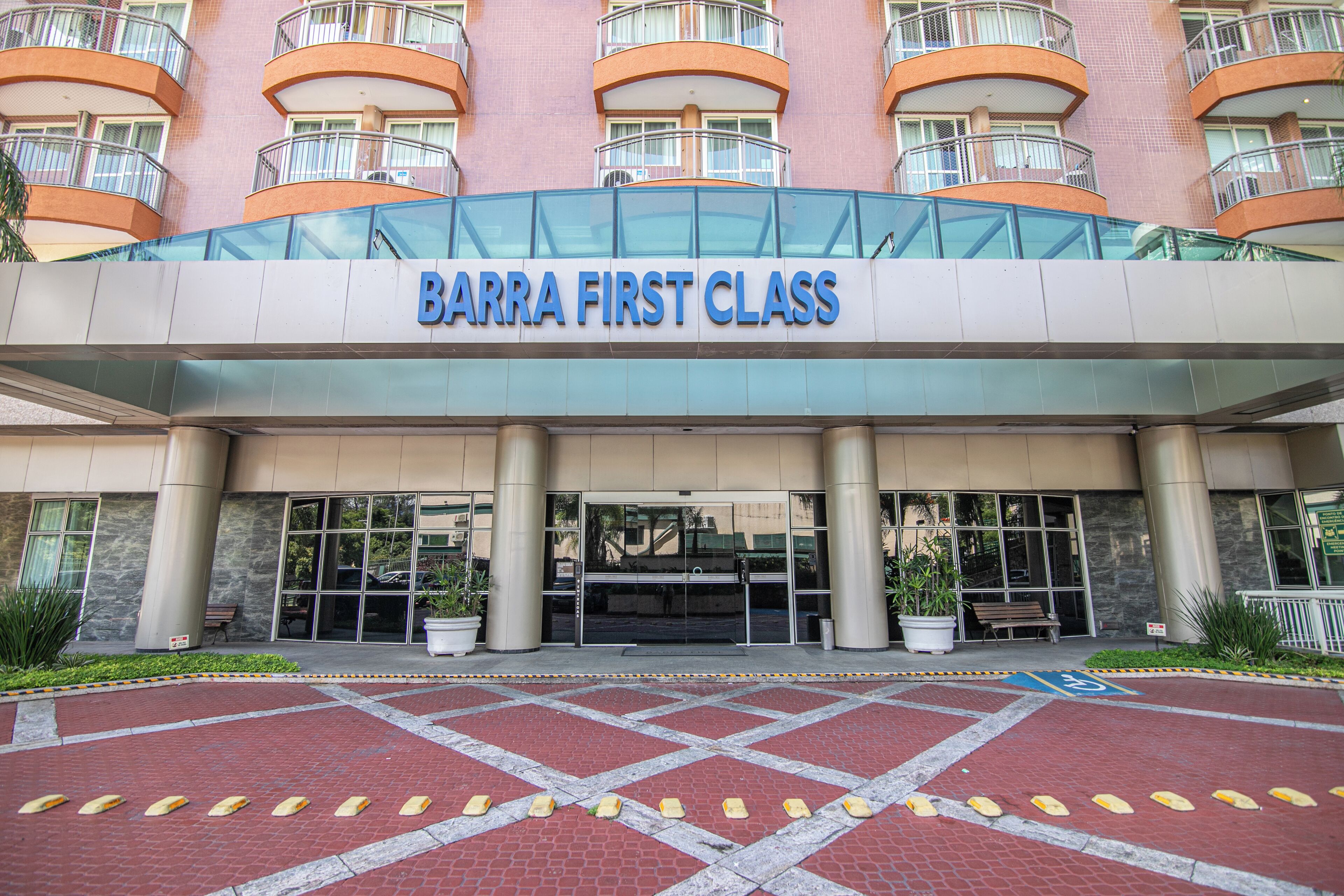 A hotel entrance with a sign reading "BARRA FIRST CLASS".