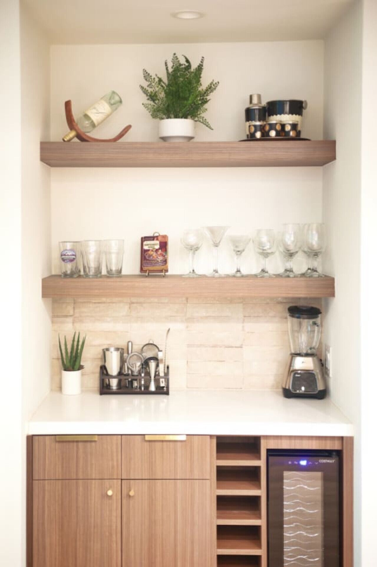 A kitchen with wooden shelves, a blender, and a coffee machine.