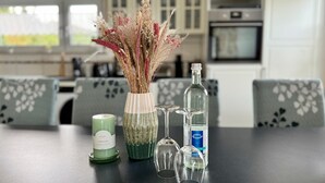 A dining table with a scented candle, a vase with dried flowers, and a bottle of water. - Refugium 2020 - The vacation apartment - 69 sqm with balcony, perfect for 4 people, max. 7 (Marienheide)