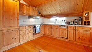 Una cucina in stile baita, con mobili a incasso, un fornello e una lavastoviglie.
