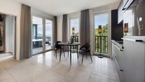 Eine moderne Küche mit Essbereich, großen Fenstern und einem Balkon mit Blick.