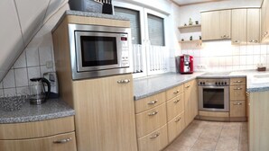 A compact kitchen with a microwave, oven, and coffee maker. - Apartment 'Mone's Kloetze' with Private Terrace, Wi-Fi and Air Conditioning (Klötze)