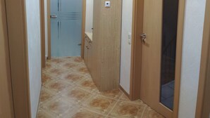 A hallway with a tiled floor, wooden doors, and a light switch on the wall. - Apartment 'Mone's Kloetze' with Private Terrace, Wi-Fi and Air Conditioning (Klötze)