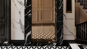 A marble-framed elevator with a geometric patterned floor. - Dai Thuy Hotel (Hai Phong)