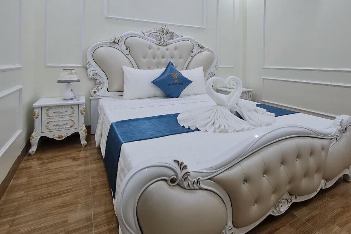 Ein Schlafzimmer mit einem großen Bett, einem Nachttisch, einer Klimaanlage und einer Deckenleuchte.