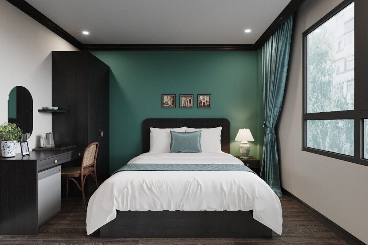 Ein Schlafzimmer mit einem Bett, einem Schreibtisch, einem Stuhl, einer Kommode und einem Fenster mit Vorhängen.