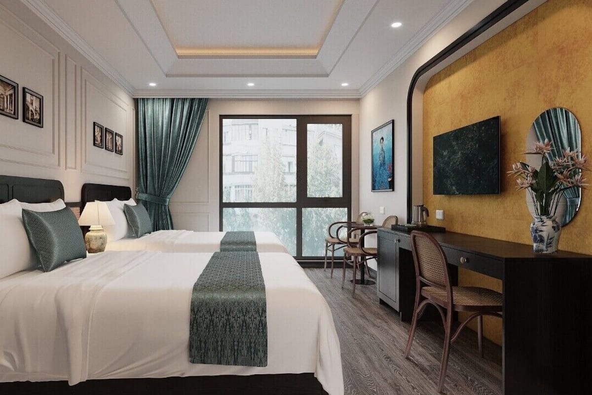 Ein Hotelzimmer mit zwei Betten, einem Schreibtisch, einem Sessel, einem Fernseher und einem großen Fenster.