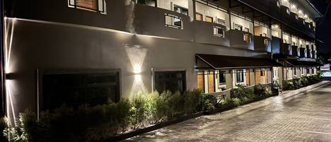 A multi-story hotel with a modern architectural design, featuring a brick facade and multiple balconies.