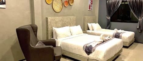 A hotel room with two beds, a sofa, and decorative wall art.