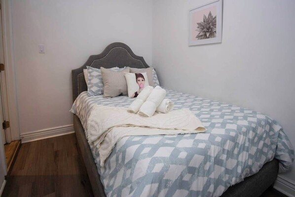 A neatly made bed with a patterned bedspread, pillows, and rolled towels. - 5 BR for 10! Prime Spot Near FR QT by YouRent! (New Orleans)