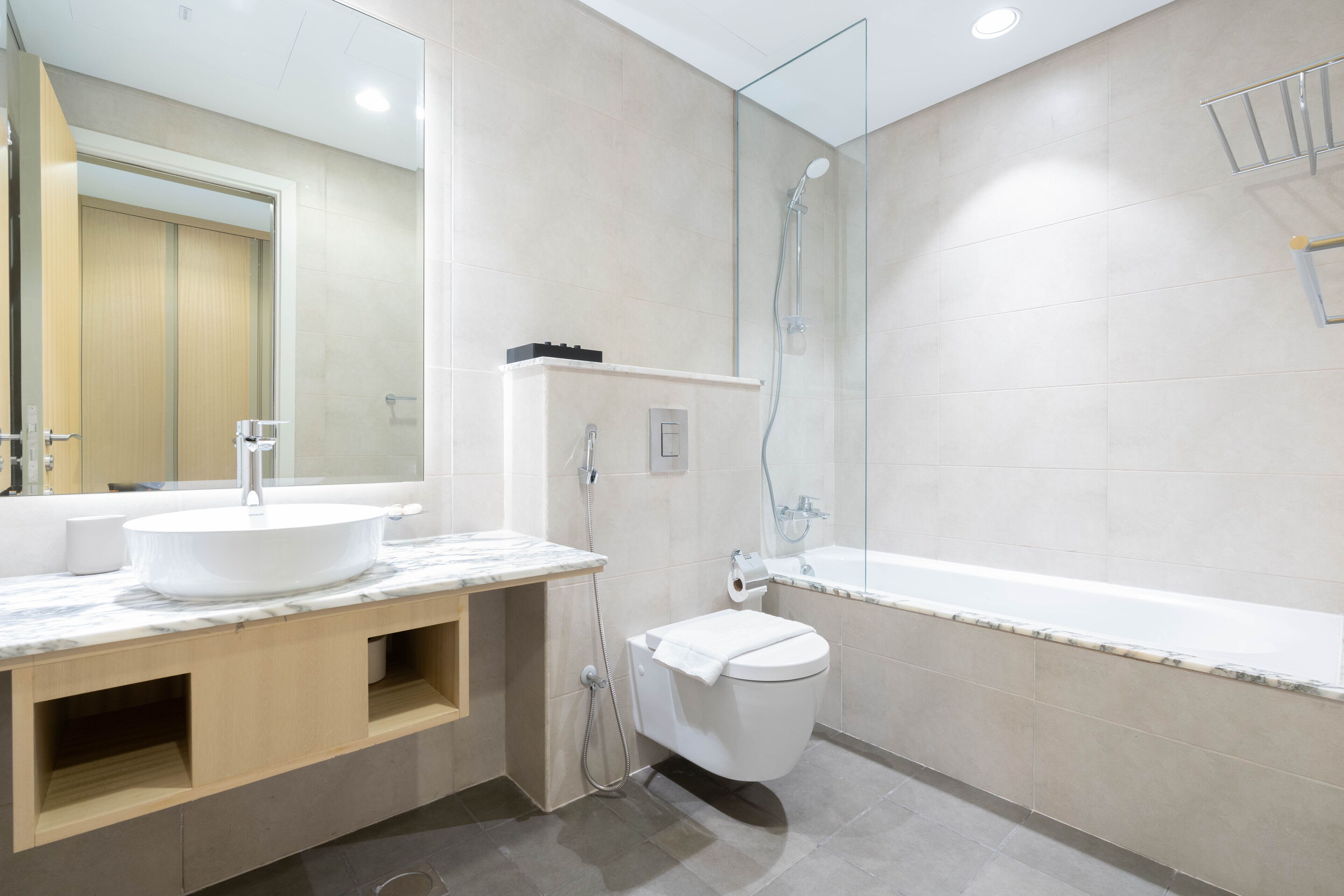 A modern bathroom with a sink, toilet, and shower.