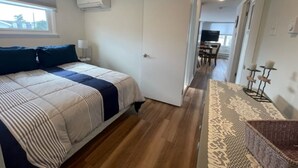 Un dormitorio con cama, ventana y aire acondicionado.