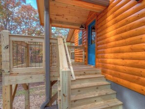 A wooden cabin with a wooden staircase leading to a blue door. - Not-so-Tiny cabin. King Bed and Secure Dog Yard. (Murphy)