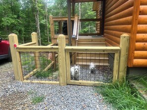 A wooden cabin with a fenced outdoor area and a gravel path. - Not-so-Tiny cabin. King Bed and Secure Dog Yard. (Murphy)